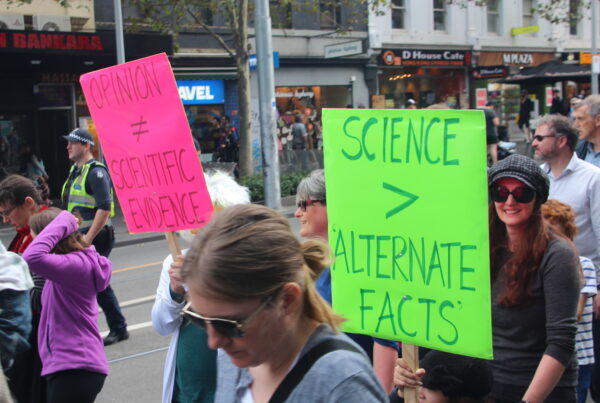 Demonstrator holding a sign to protest disinformation.