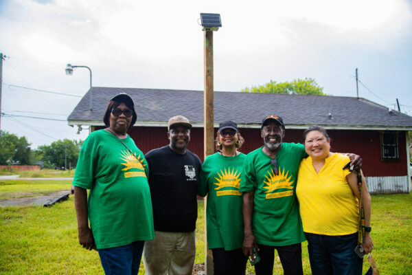 Grace Tee Lewis (R) partners with residents from the Sunnyside neighborhood in Houston, Texas to install a new air quality monitor in their community.